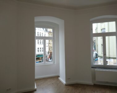 Frisch gestrichener heller Innenraum mit großen Altbaufenstern in Köln