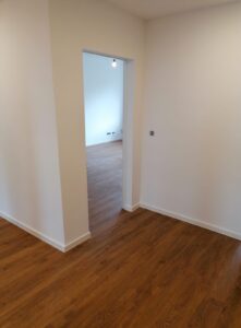 Renovierter Wohnraum mit Parkettboden und frisch gestrichenen weißen Wänden in Köln
